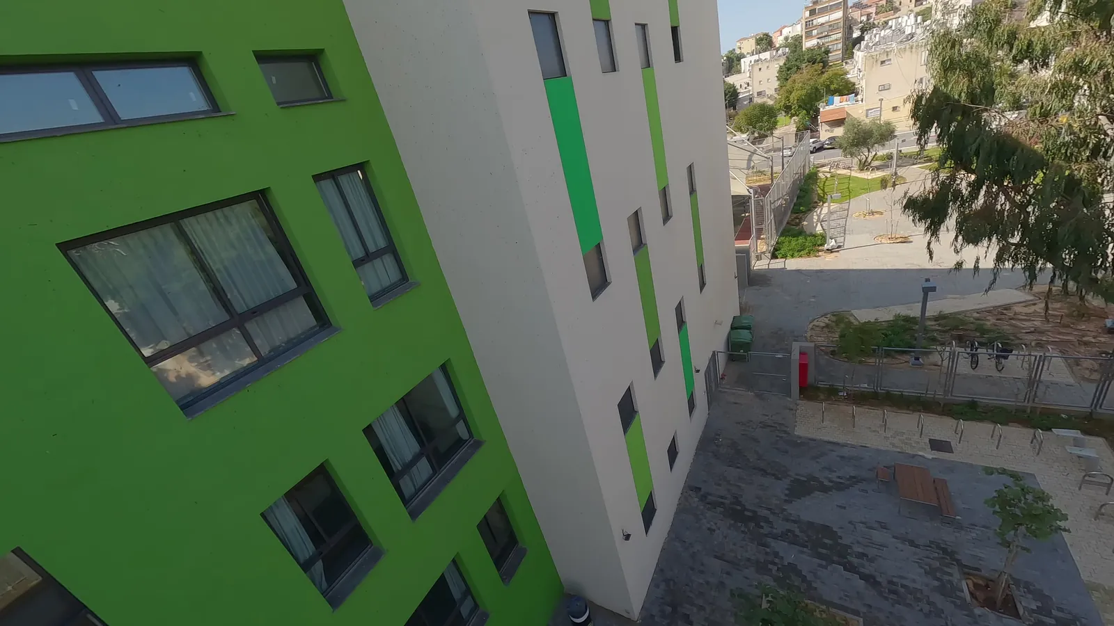 טיסת FPV יורדת לאורך חזית המבנה אל החצר