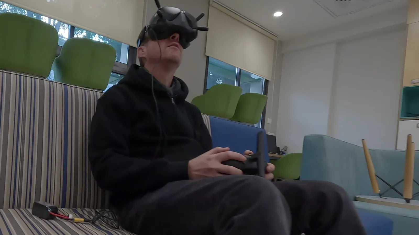 מטיס FPV עם משקפי וידאו ושלט, יושב בתוך המבנה בזמן טיסה