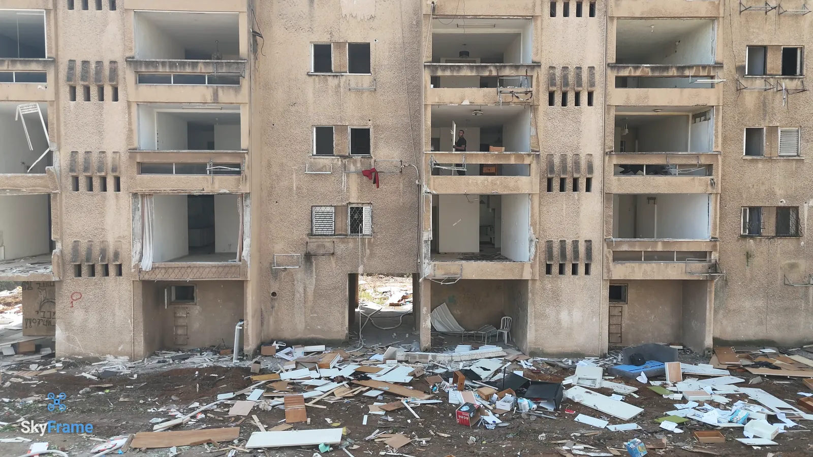 חזית של בניין שהתרוקן לפני ההריסה: החלונות פורקו, ושאריות מהדירות ערומות למטה